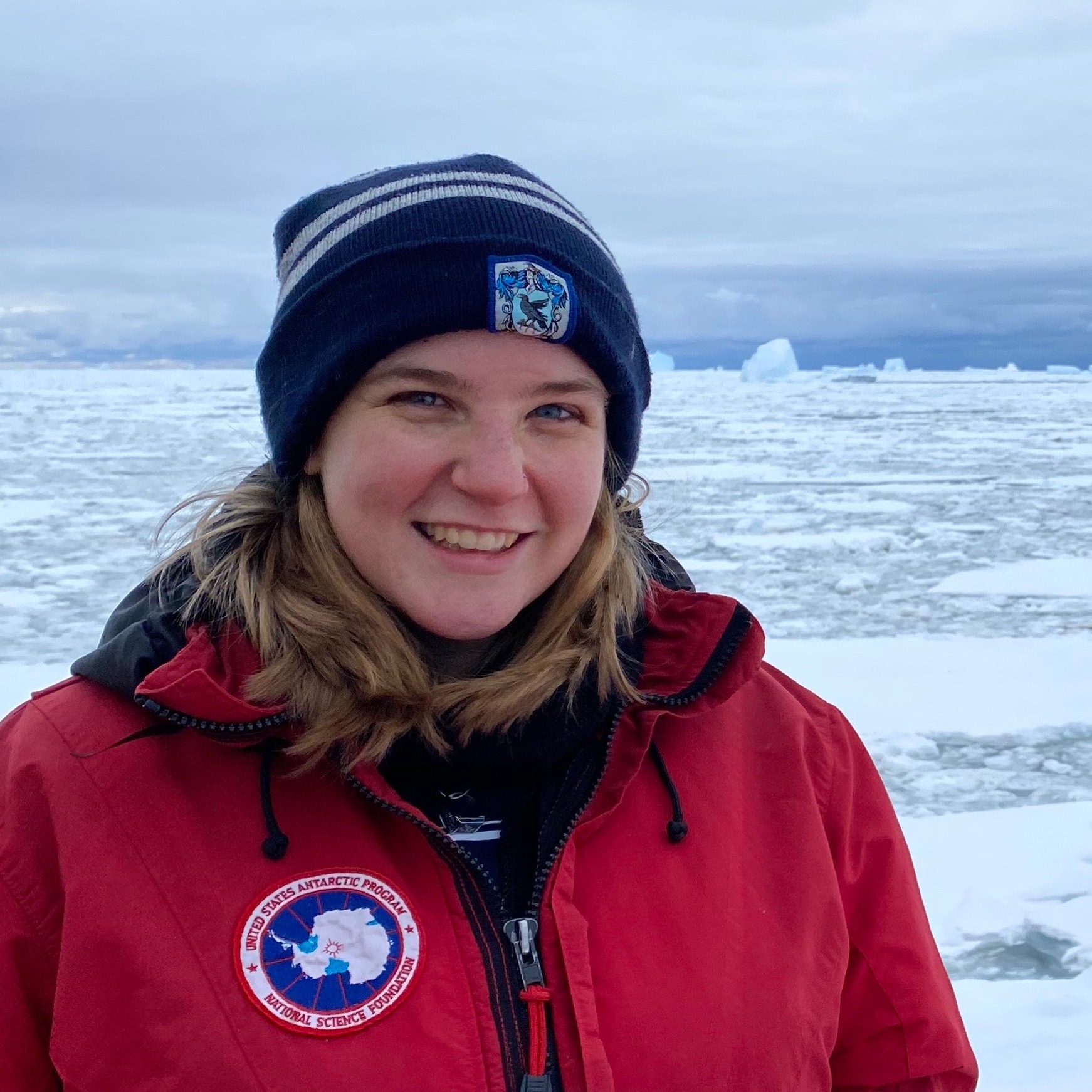 Picture of Lily Dove, a smiling person in front of sea ice